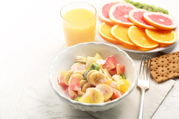 Fruitsalade op houten achtergrond. Gezond eten concept. — Stockfoto