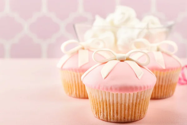 Gustoso cupcake con fiocco e scarpe bambino, ciuccio su sfondo colore — Foto Stock