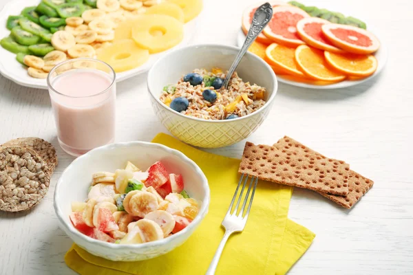 Tasty oatmeal and fruit salad on wooden background. Healthy eating concept. — Stock Photo, Image