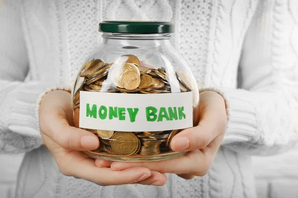 Woman hands with money in glass jar — Stock Photo, Image