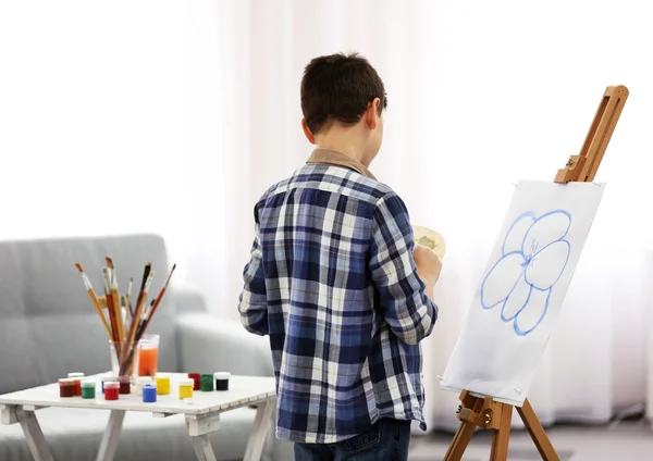 Boy drawing on easel