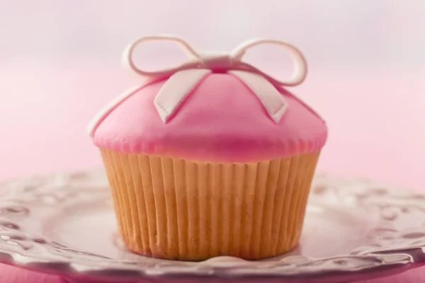 Välsmakande cupcake med rosett på färg trä bakgrund — Stockfoto