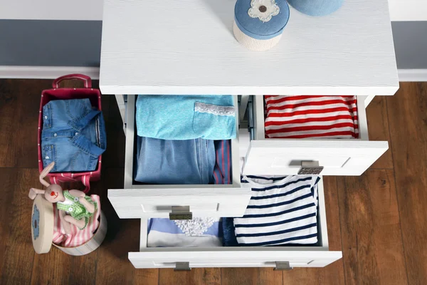 Clothes in wooden chest of drawer — Stock Photo, Image