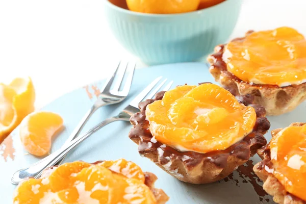 Gâteaux sucrés avec mandarines sur la table, gros plan — Photo