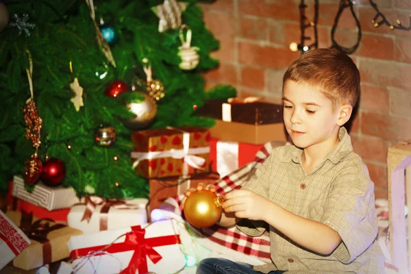 Niño colgando juguetes en un abeto —  Fotos de Stock