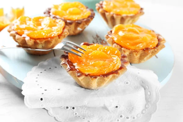 Sweet cakes with tangerines on table, close up — Stock Photo, Image