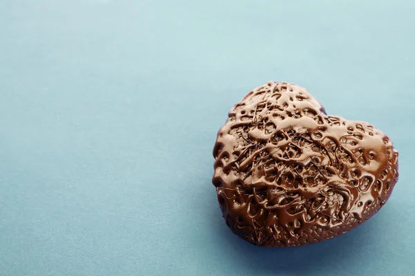 Coração de chocolate em um fundo azul, close-up — Fotografia de Stock