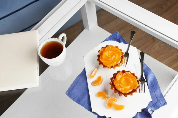 Sweet cakes with tangerines on table, close up — Stock Photo, Image