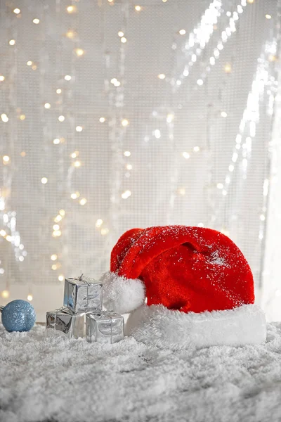 Santa Claus hat with bauble and gift boxes — Stock Photo, Image