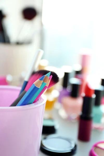 Lápis de maquiagem e escova com cosméticos — Fotografia de Stock