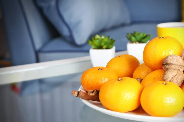 Plaat met vers mandarijnen op tafel in woonkamer, close-up — Stockfoto