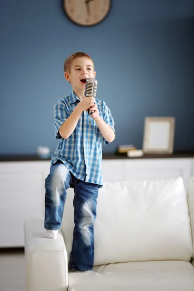 Mały chłopiec śpiewa do mikrofonu — Zdjęcie stockowe
