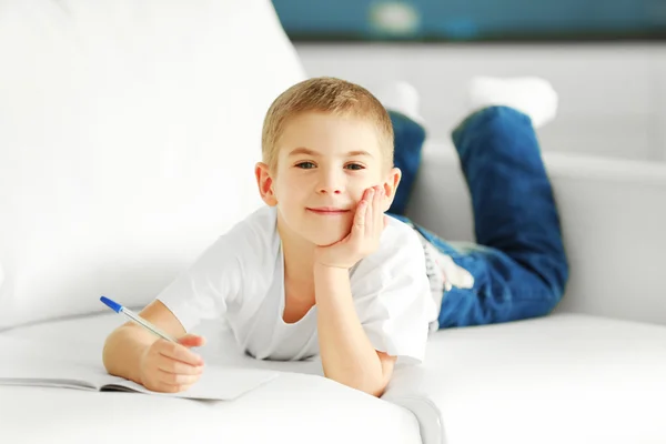 Menino com caderno e caneta — Fotografia de Stock