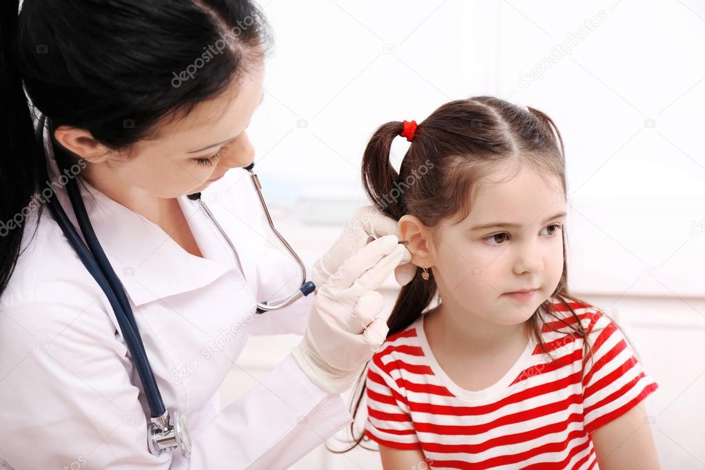 Doctor examining child's ears