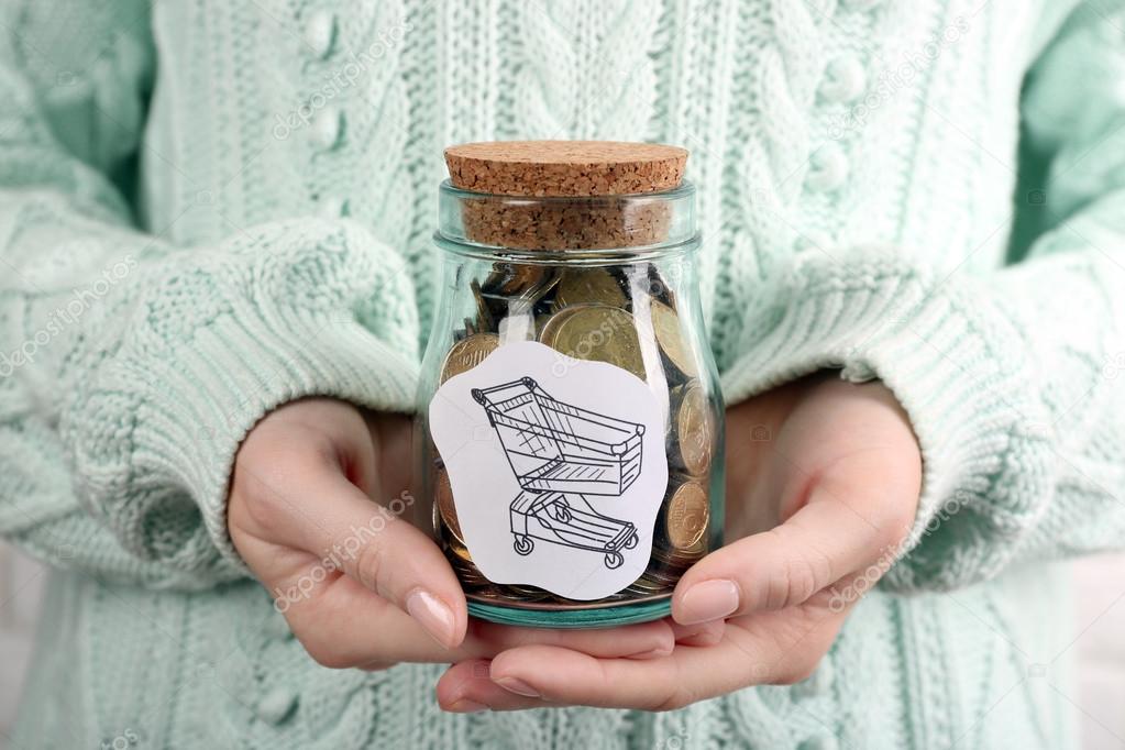 Woman hands with money in glass jar