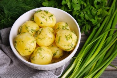 Masada bir kapta yeşillikleri ile haşlanmış patates yakın çekim