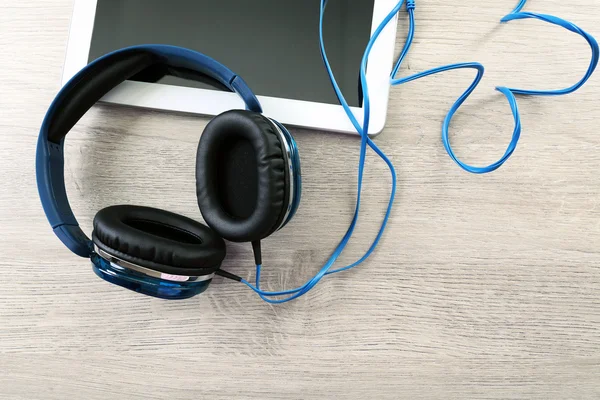 Headphones with tablet on  table — Stock Photo, Image