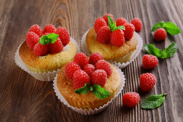 Вкусные кексы с ягодами и свежей мятой на деревянном столе вблизи — стоковое фото