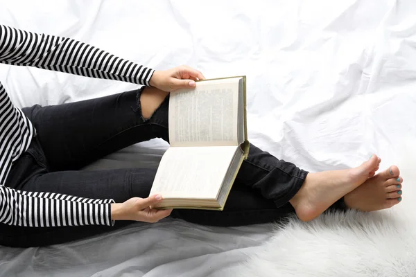 Vrouw in spijkerbroek op bed — Stockfoto