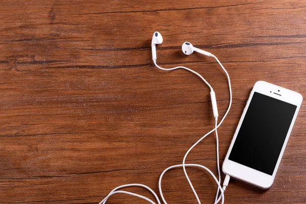 Celular branco com fones de ouvido — Fotografia de Stock