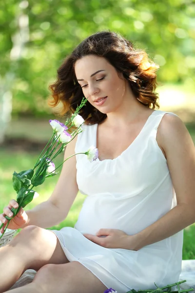 Ελκυστική έγκυος γυναίκα με λουλούδια — Φωτογραφία Αρχείου