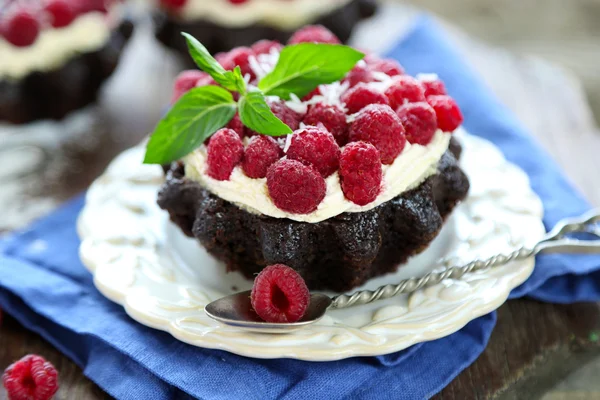 Sweet cakes with raspberries on wooden table background — Stock Photo, Image