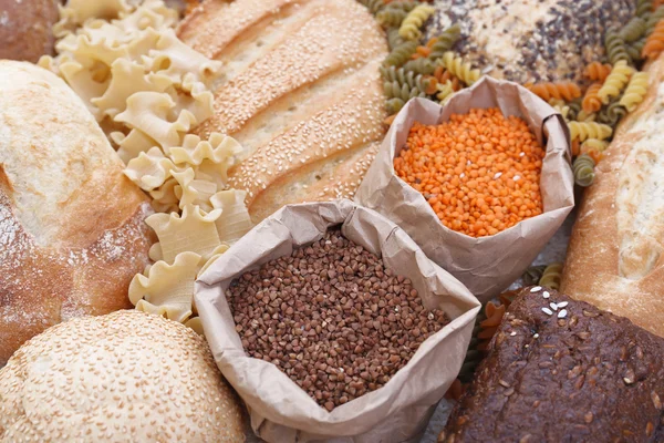 Pães mistos, macarrão e grãos de fundo, close-up — Fotografia de Stock