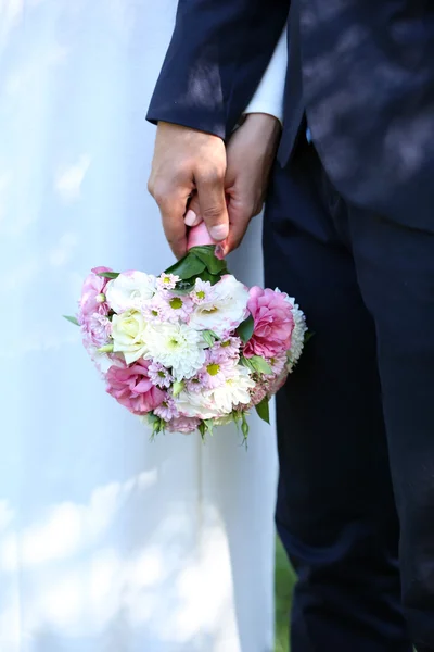 Bride and groom holding  bouquet — Stock Photo, Image