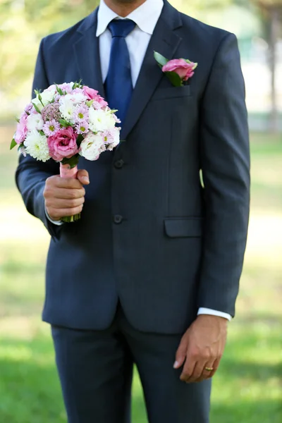 Noivo segurando buquê de casamento — Fotografia de Stock