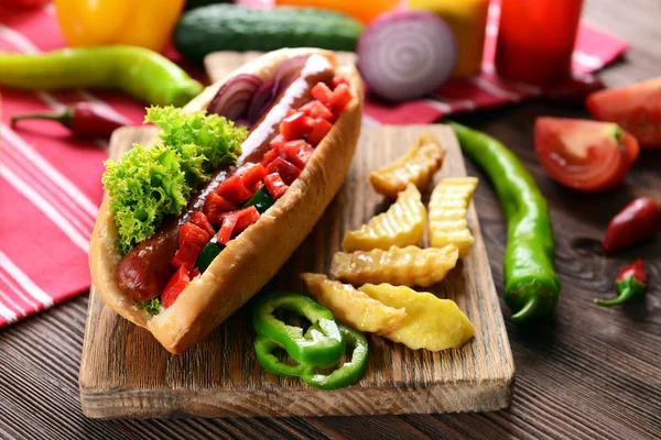 Hot dogs et légumes sur planche à découper en bois — Photo