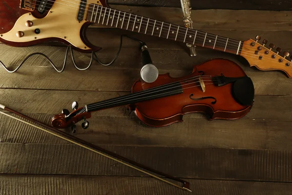 Guitarra elétrica, violino, flauta e microfone sobre fundo de madeira — Fotografia de Stock