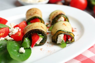 Kabak rulo peynir, biber ve roka ile tabağında, yakın çekim, tablo arka plan üzerinde