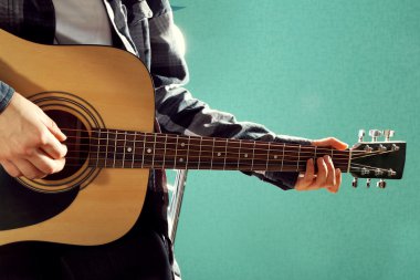 Müzisyen gitar çalan ve vokalde üzerinde mavi arka plan, yakın çekim