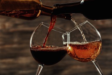 Beyaz ve kırmızı ahşap arka plan üzerinde bardaklarda dökme şarap