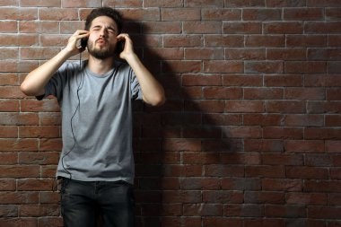 Kulaklıkla müzik dinleyen genç adam. 