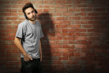 Kulaklıkla müzik dinleyen genç adam. 