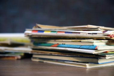 Eski kitaplar duvara karşı ahşap masa üzerinde kazık, yakın çekim