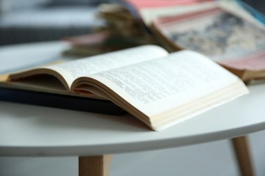 Eski kitaplar beyaz masa üzerinde kazık, yakın çekim