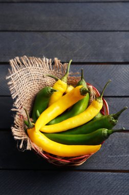 Ahşap arka plan üzerinde hasır sepet içinde Chili biber