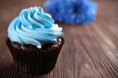 Çikolatalı kek ve ahşap arka plan üzerinde çiçekler