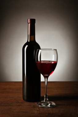 Şarap cam ve şişe masanın üzerinde koyu arka plan üzerinde