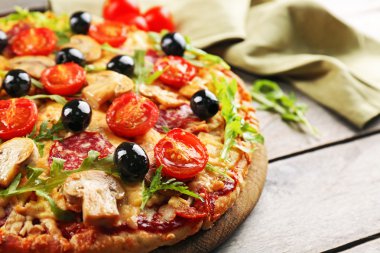 Ahşap masa üzerinde malzemelerle güzel lezzetli pizza