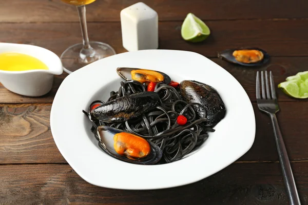 Cooked pasta, mussel and lime on brown wooden background — Stock Photo, Image