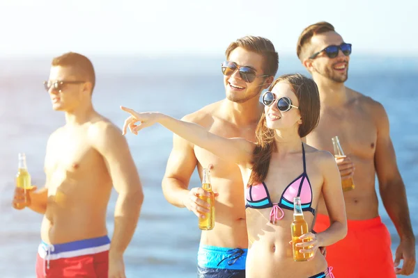 Amigos felices bebiendo cerveza en la playa —  Fotos de Stock