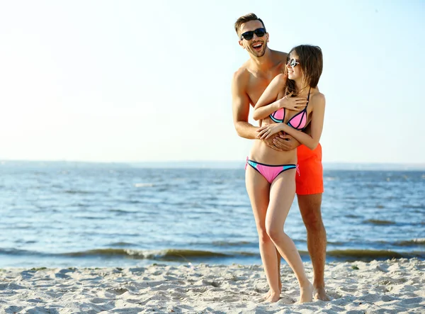 Chico abrazando chica en playa — Foto de Stock