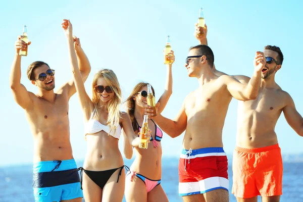 Happy vrienden drinken bier op strand — Stockfoto