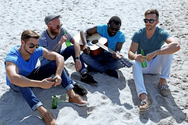 Homens sentados na areia — Fotografia de Stock