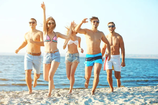 Happy přátelé běží na pláži — Stock fotografie