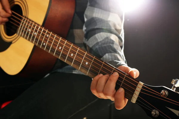 Músico toca la guitarra sobre fondo negro, de cerca — Foto de Stock