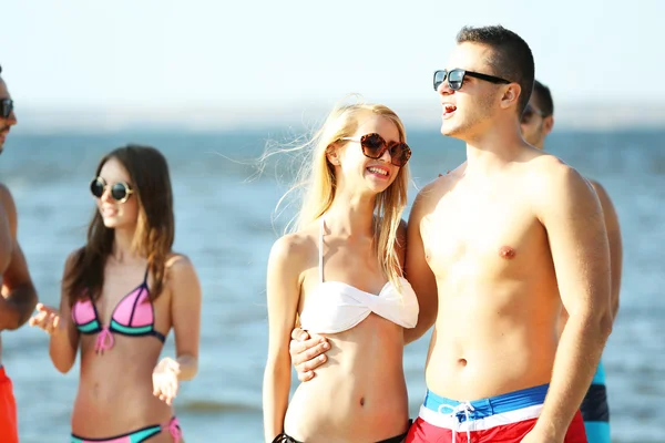 Coppia felice e amici rilassarsi in spiaggia — Foto Stock